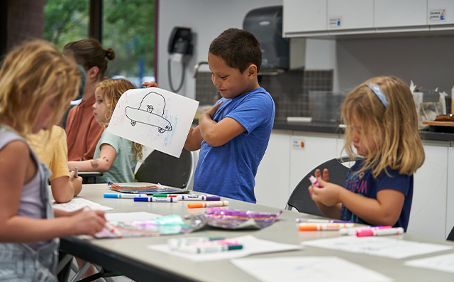 Kids draw together in a summer camp class